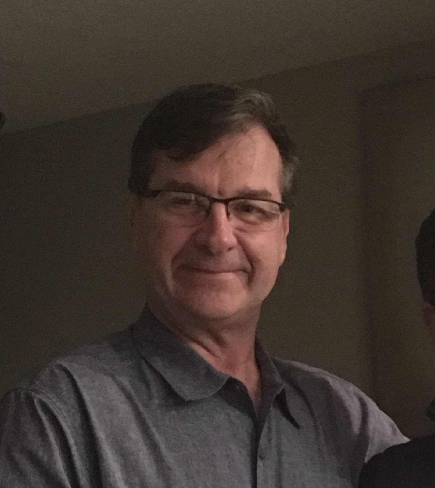 A man with glasses is smiling for the camera.