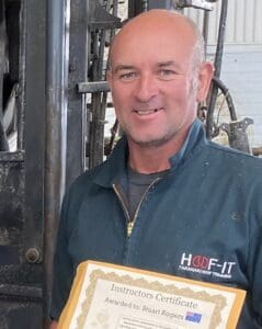 Man holding framed certificate in workshop
